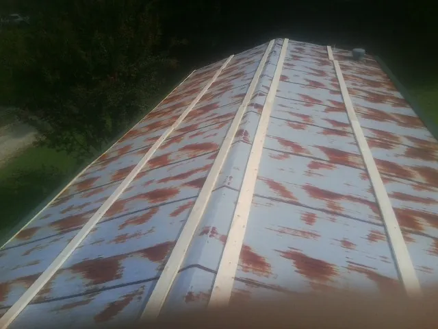 Rusted metal roof panels with new wood purlins before replacement — Storm Damage Roof Repair in Piedmont by Roofing Brothers