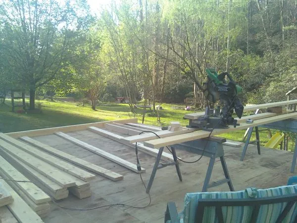 Miter saw and framing lumber on a deck under construction in Piedmont